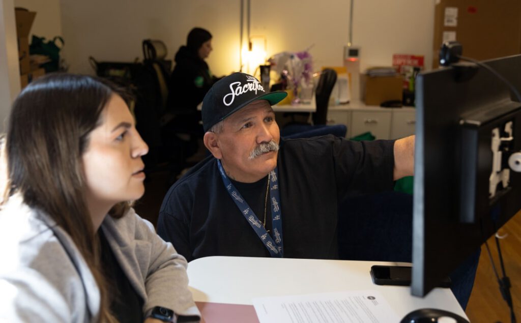 Two people looking at a computer screen collaborating